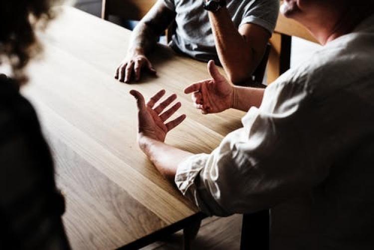 three people talking at a table